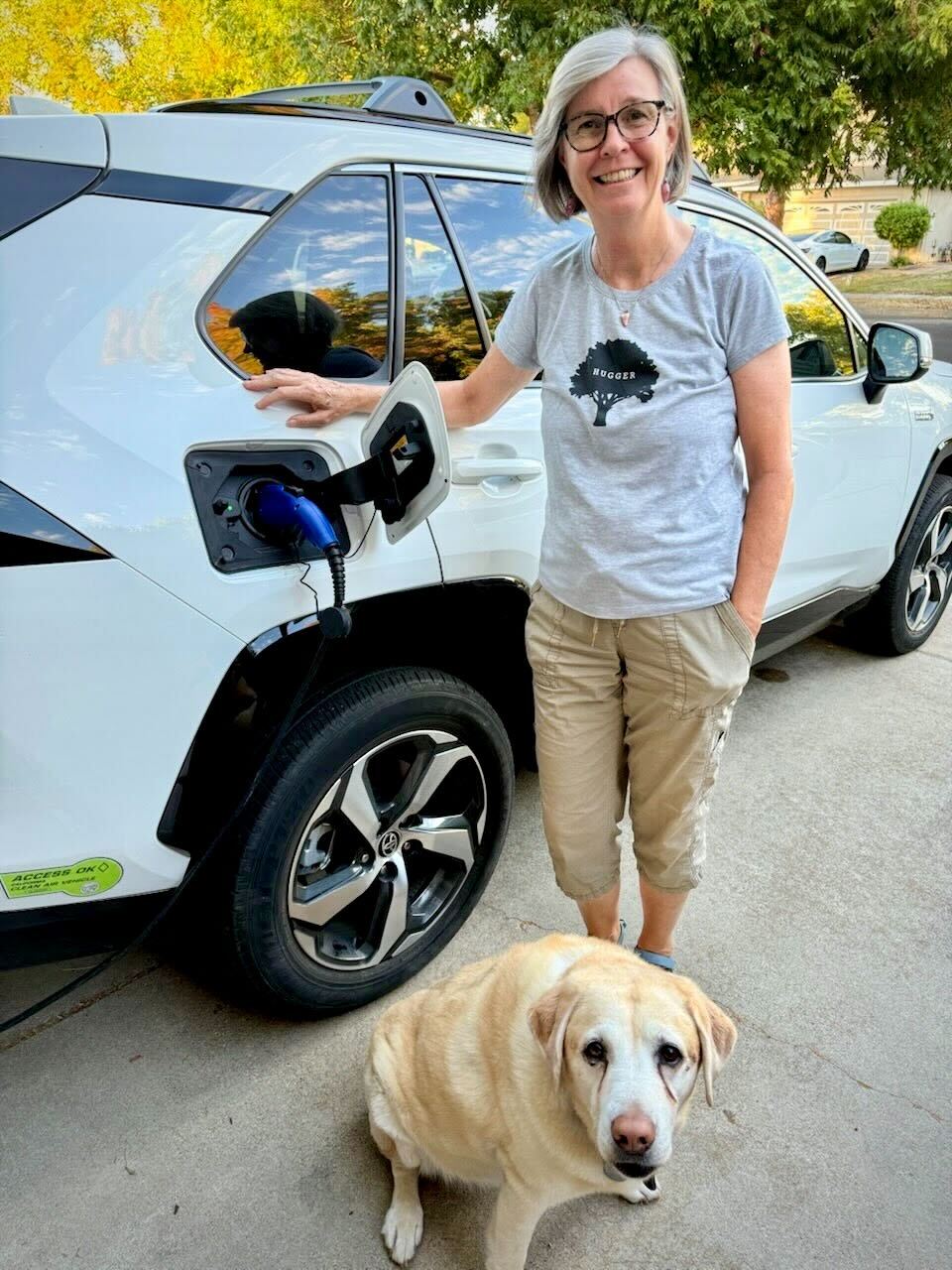 Linden, pictured next to her white Rav 4. At her feet is her yellow lab, Rylee. 