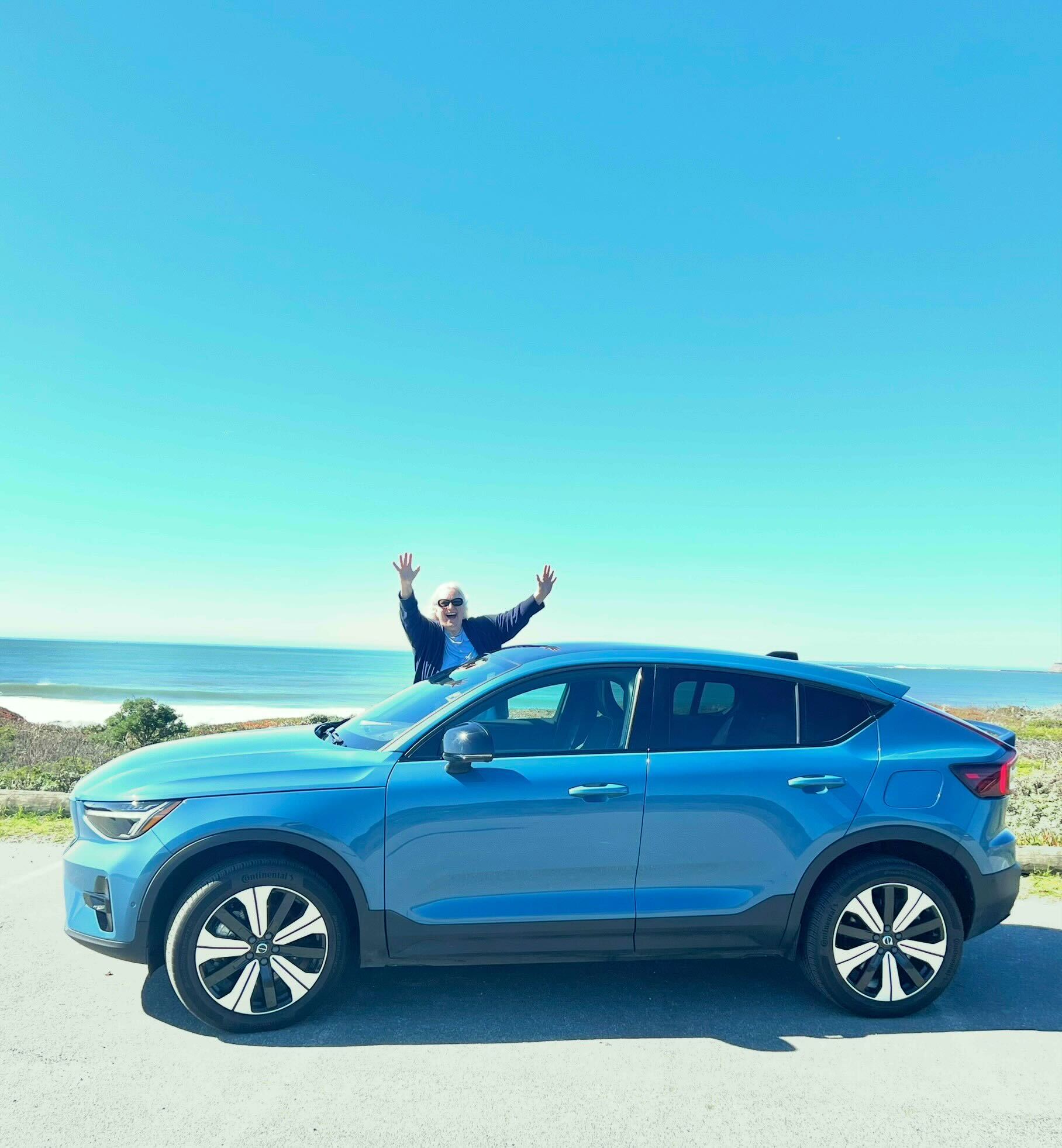 Janean standing with arms raised behind her used Volvo C40