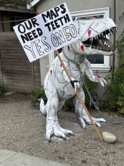 Statue of local T-rex, Dug, holding a Yes on 50 sign