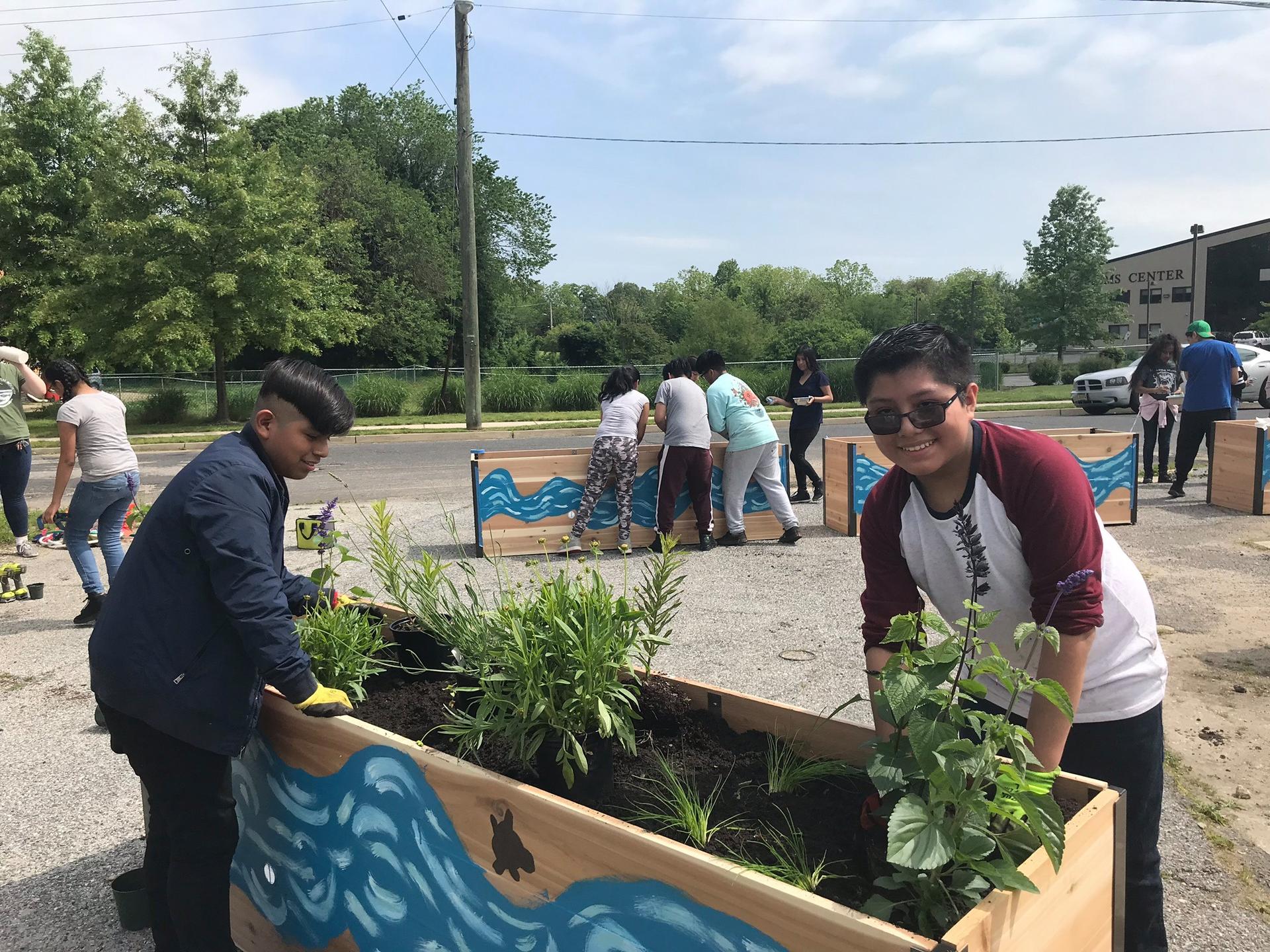 kids adding plants to a planter box