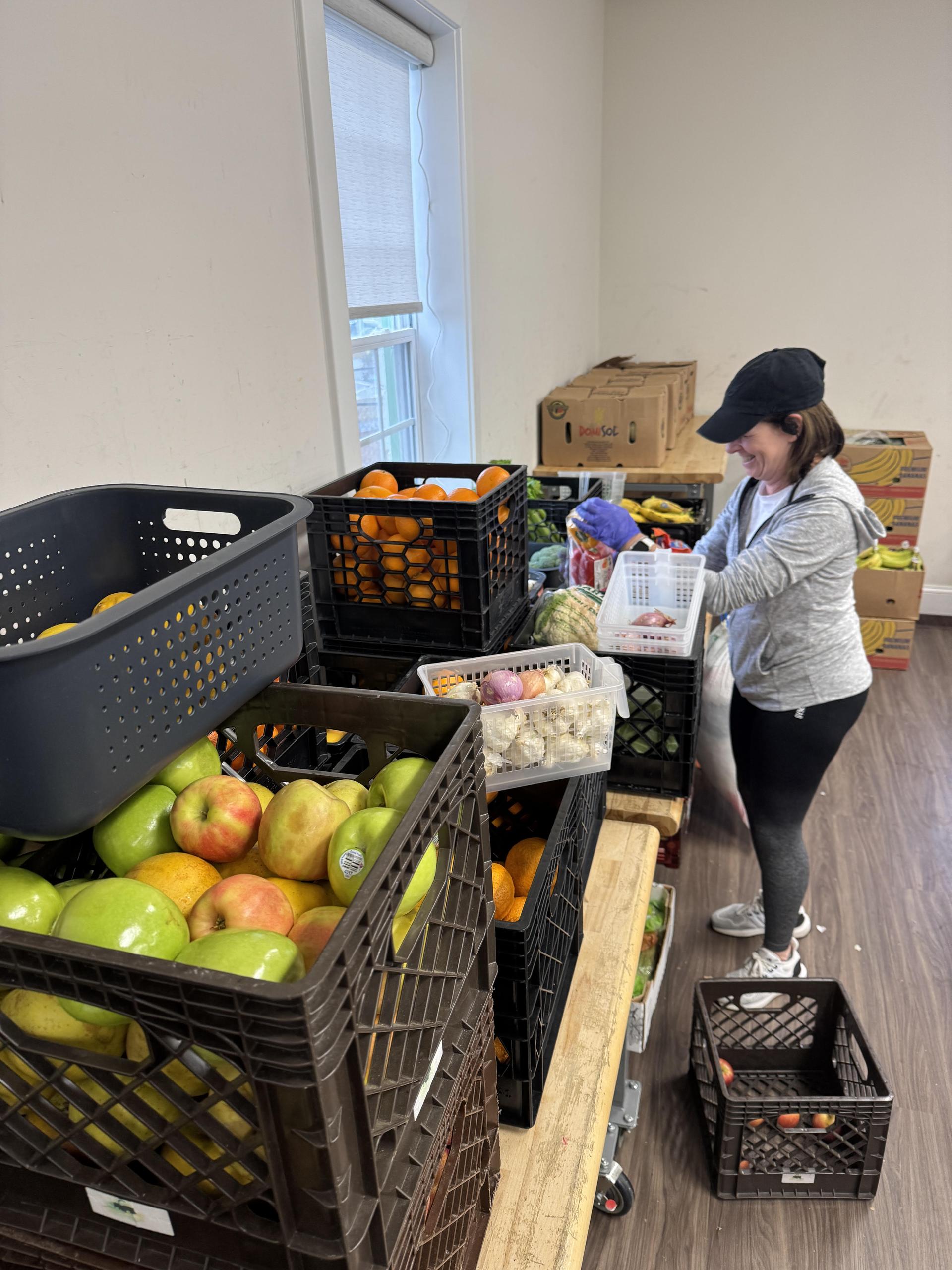 Volunteer inspecting fresh produce donations at the Pantry
