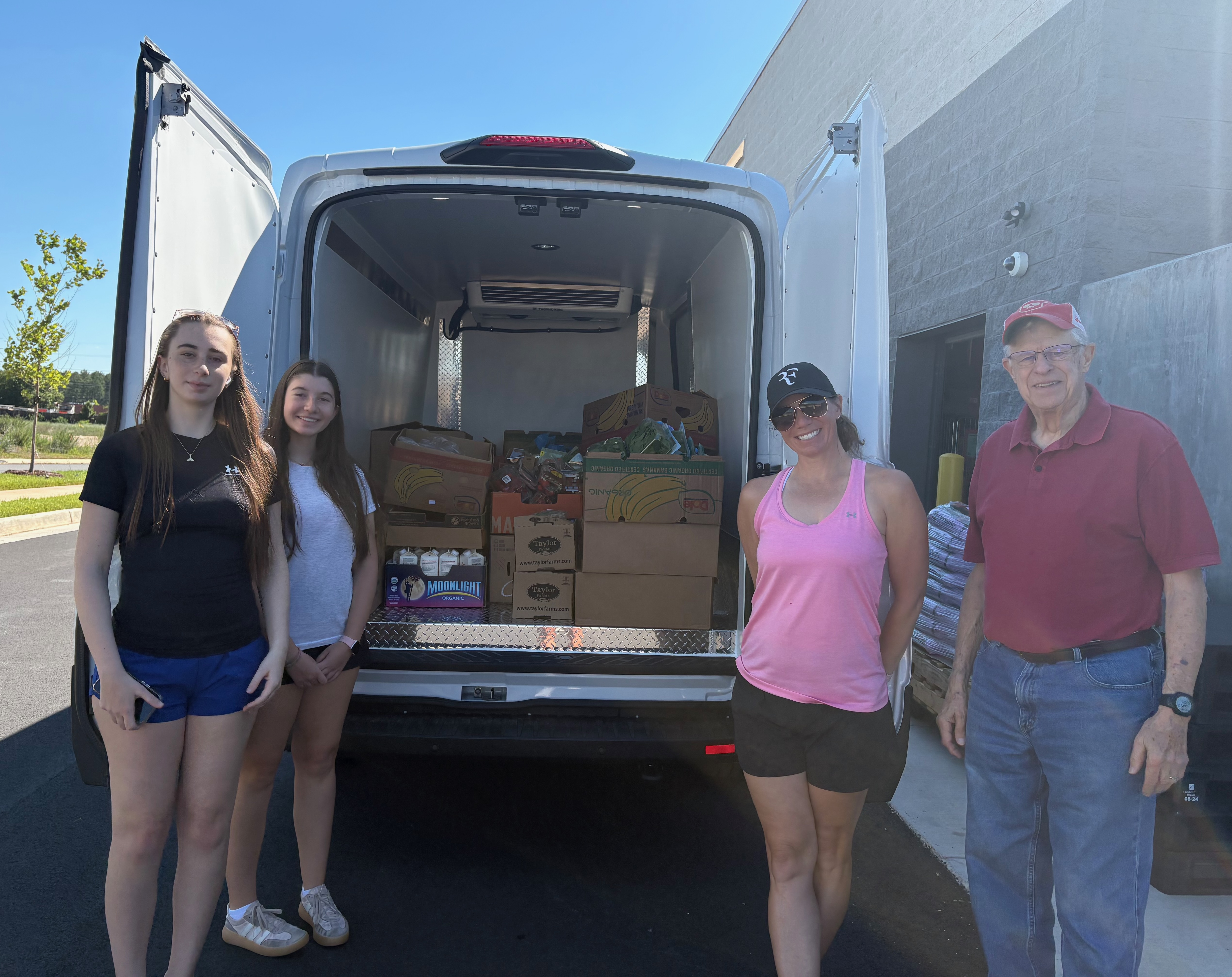 Four DSFP volunteer drivers standing in front of van loaded with fresh donations