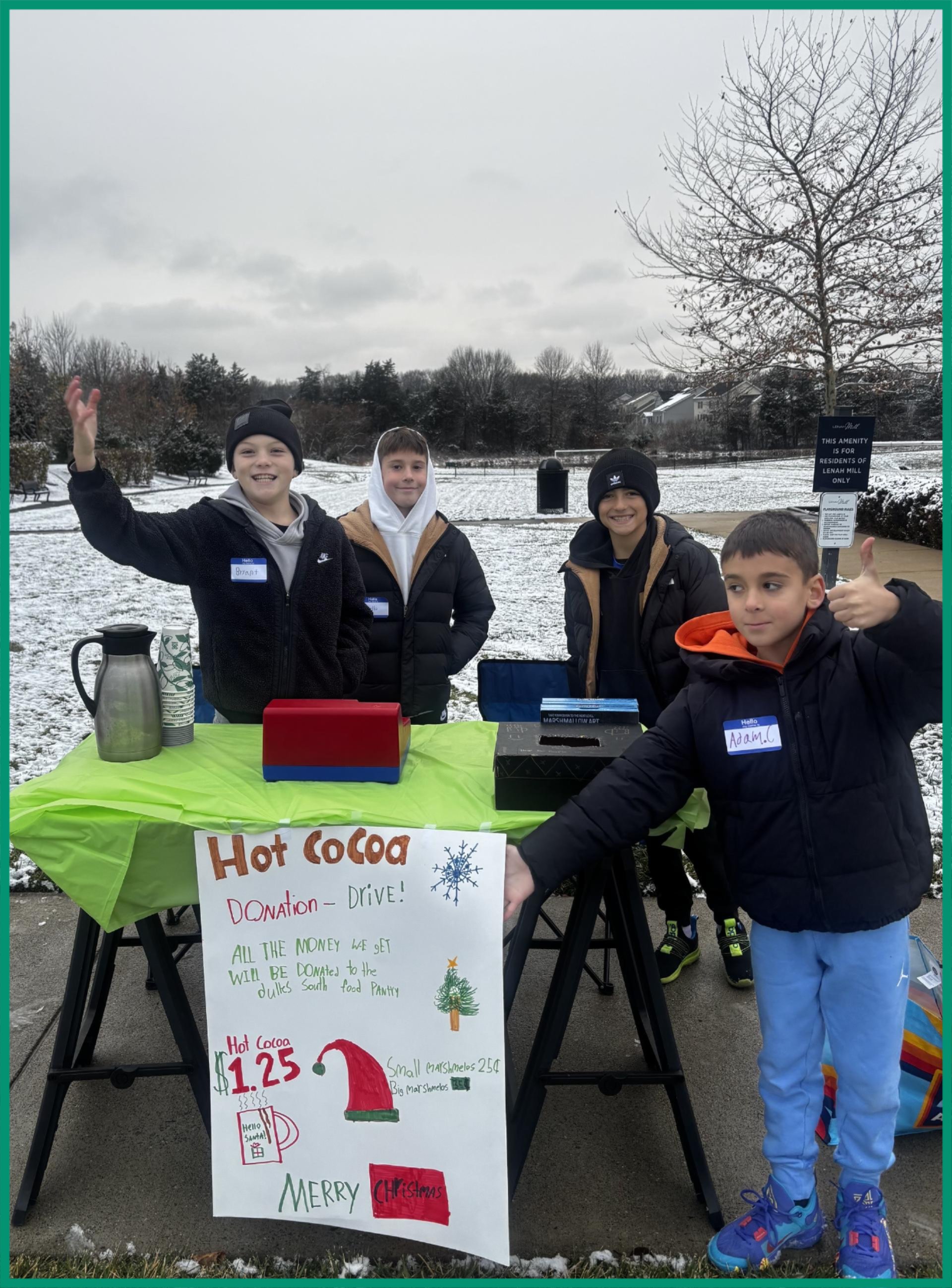 Group of friends standing at their Hot Cocoa stand
