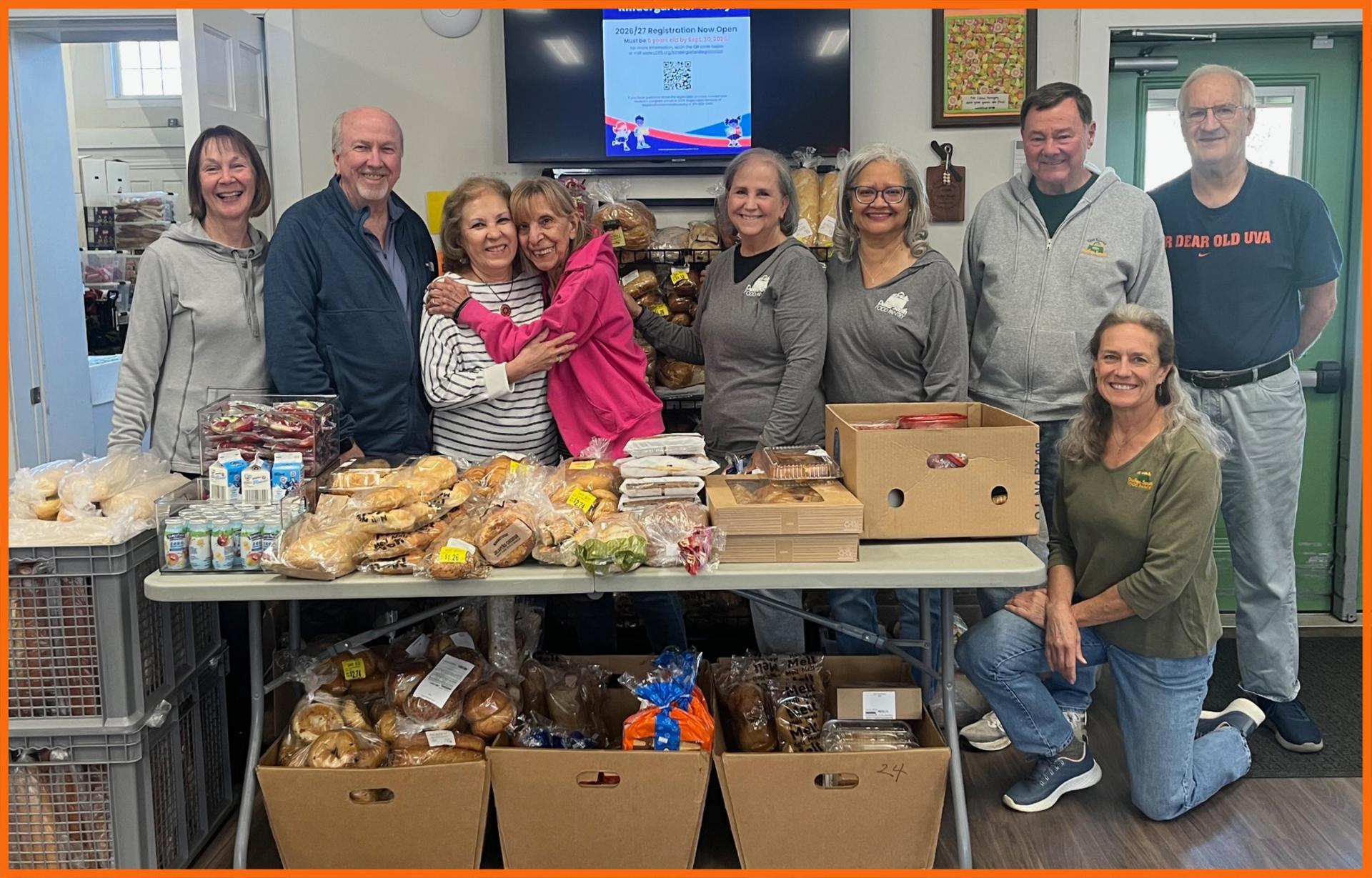 Volunteers posing together in the Pantry behind donated bread bakery items