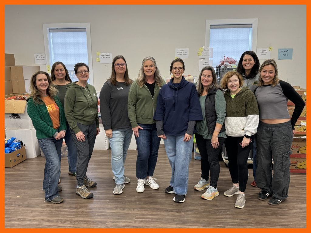 Group of staff members standing together in front of produce donations