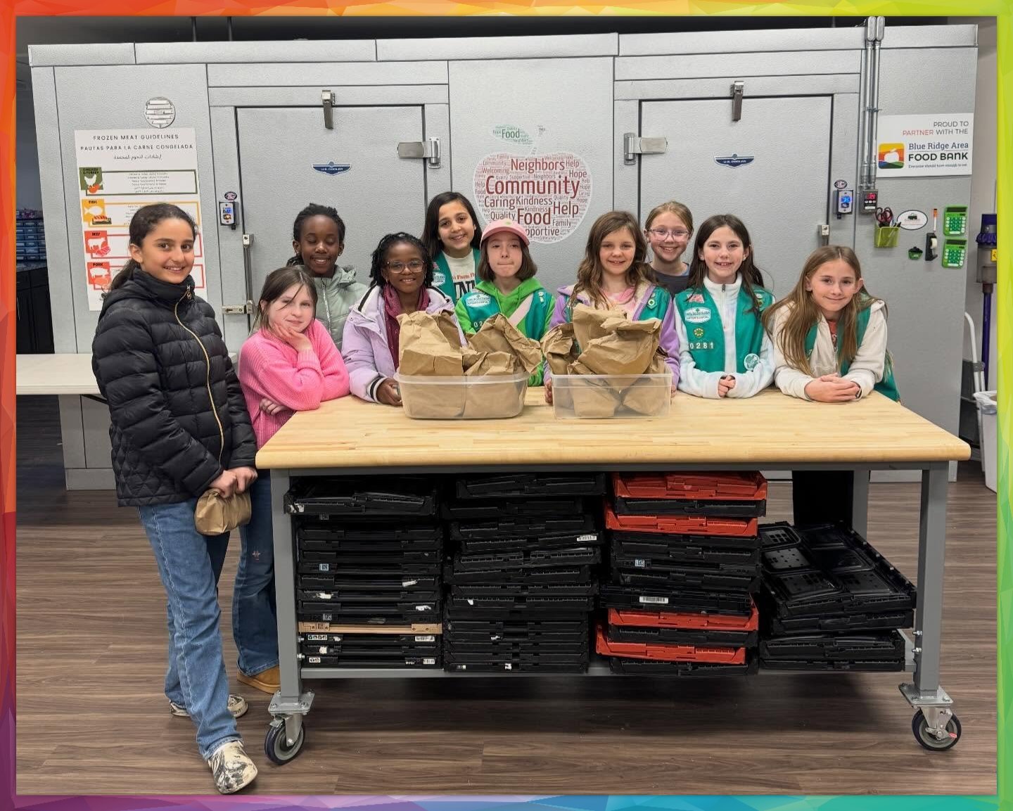 Group of girl scouts posing in front of the Pantry refrigerator doors
