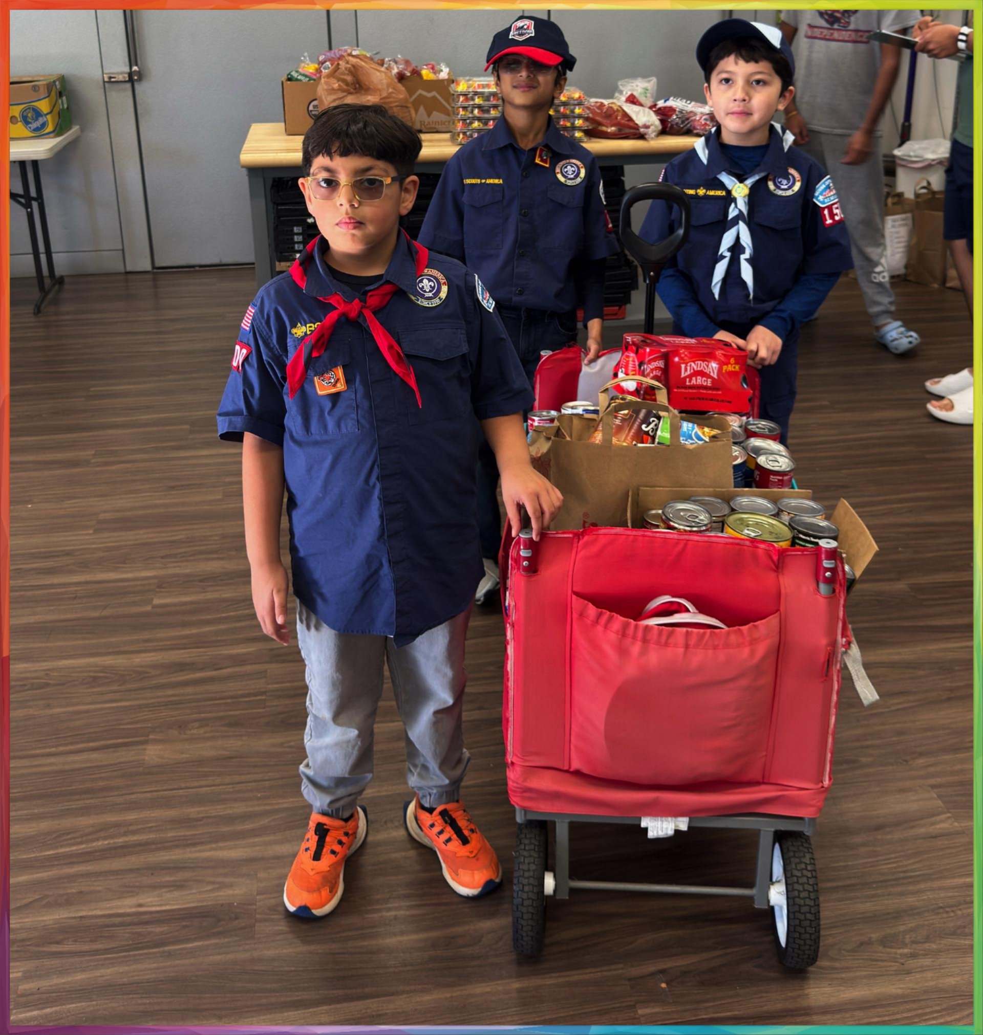 Scouts with food donations in a red wagon