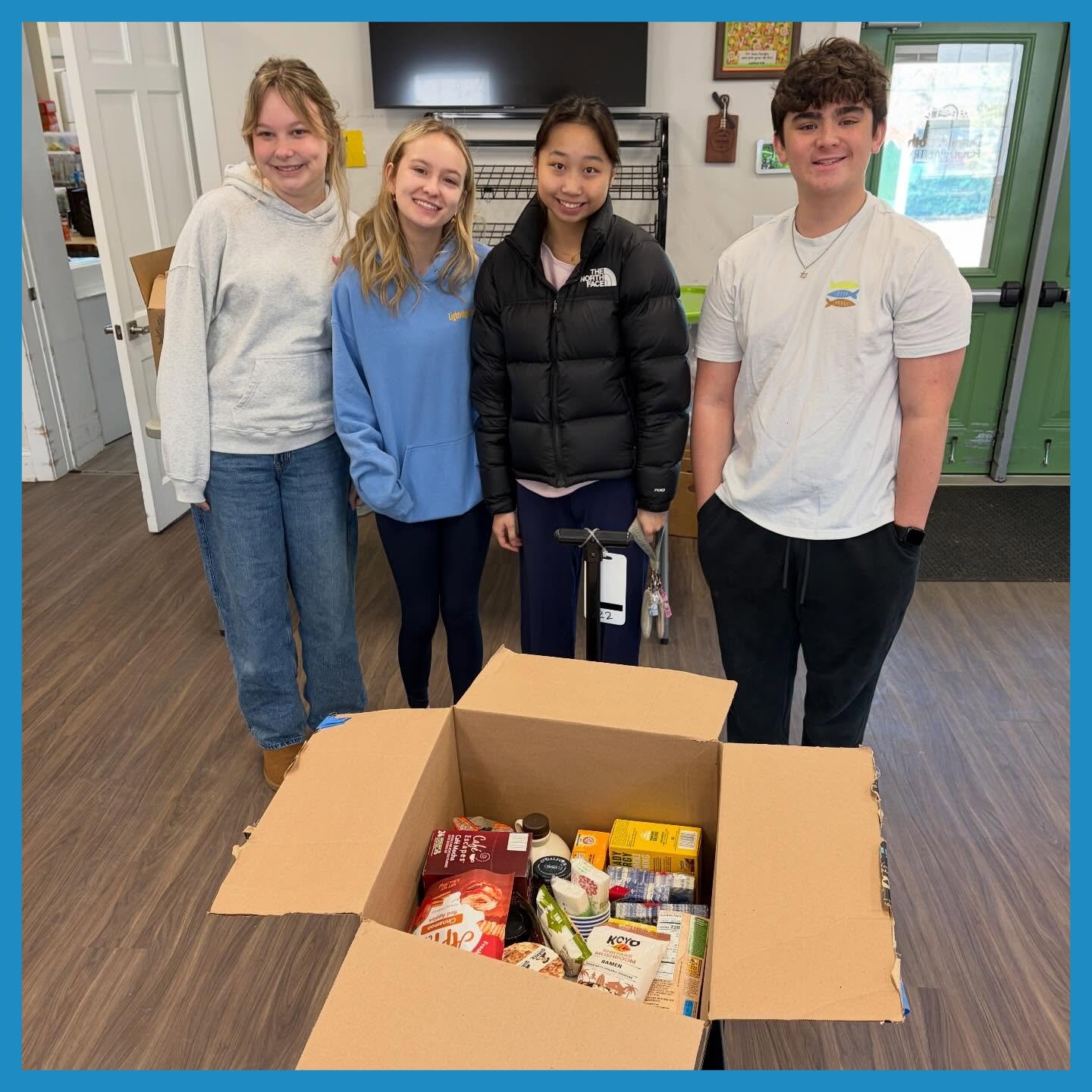 Students standing behind box of food donations in the Pantry