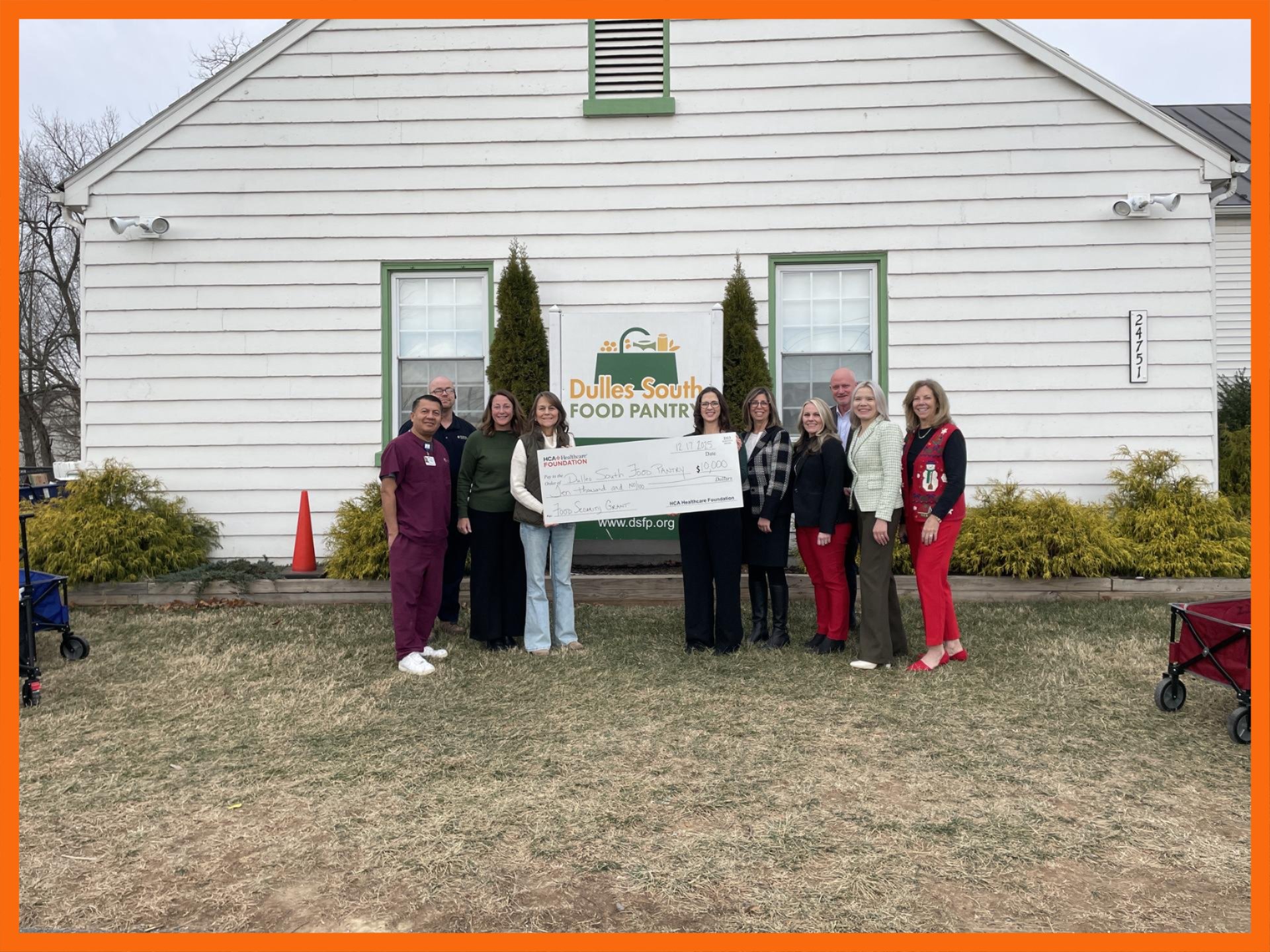 People standing in front of the Food Pantry holding ceremonial check.