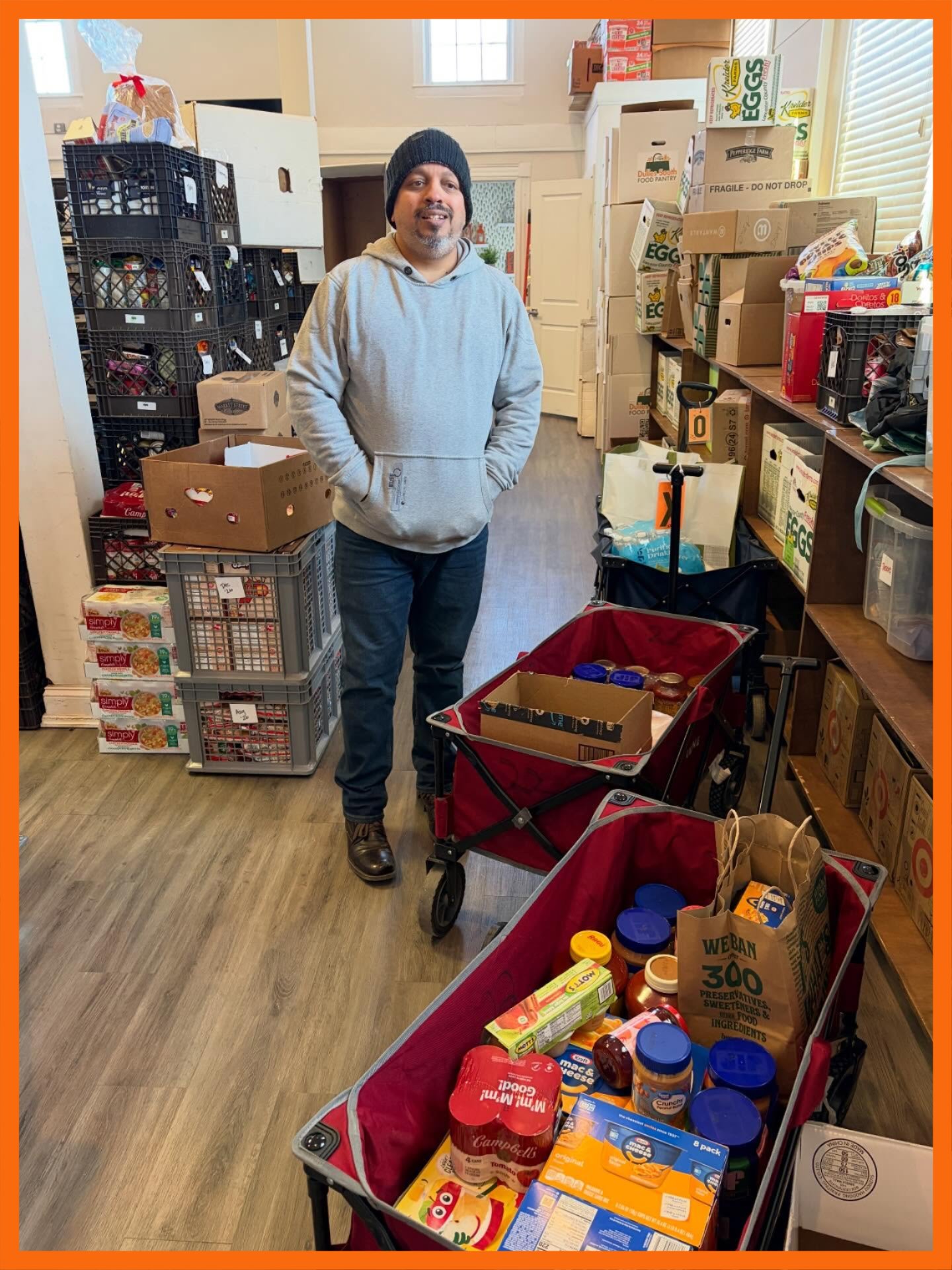Person standing in the Pantry next to wagons of food donations