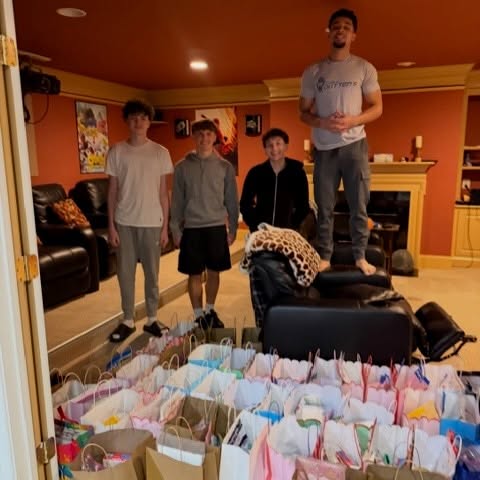 Four students standing near 55 assembled Birthday Bags