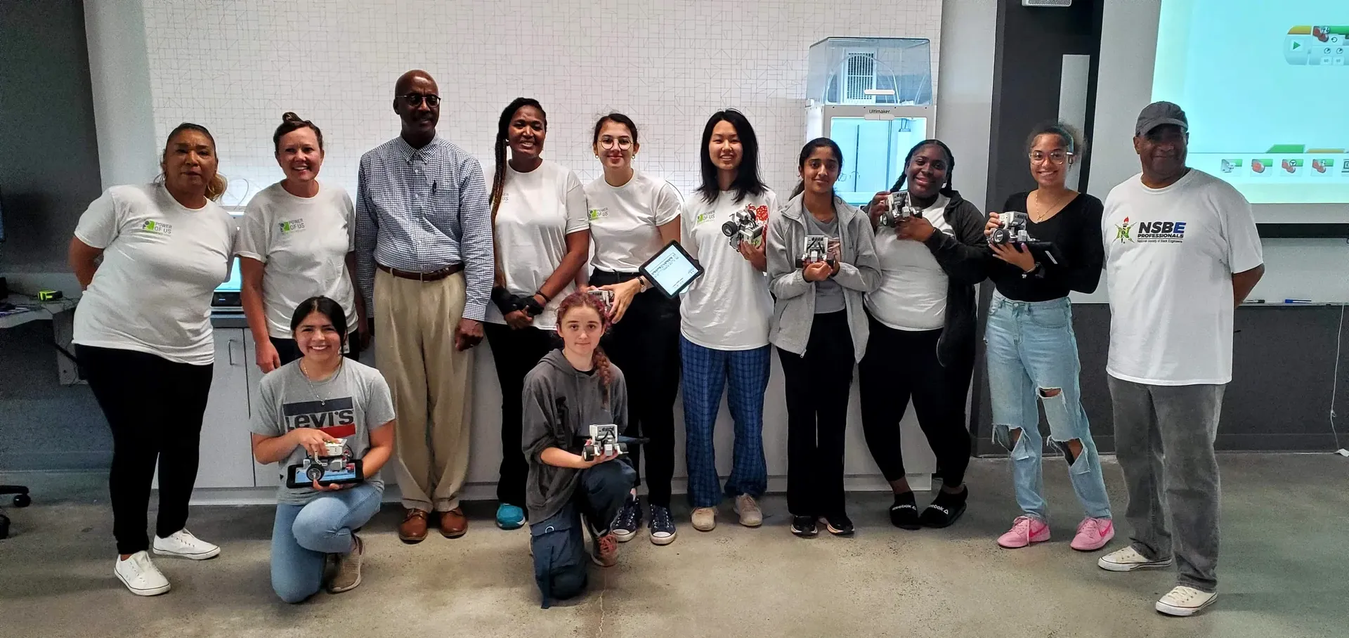AiSymmetry students holding their coding creations