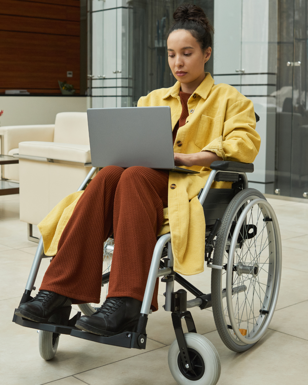 Black woman in a wheelchair working on a laptop