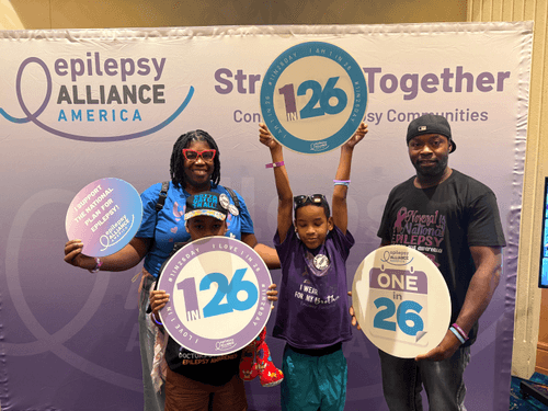 A family of 4 holding signs of epilepsy support.