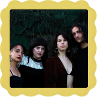 Four people posing together against a dark, leafy background