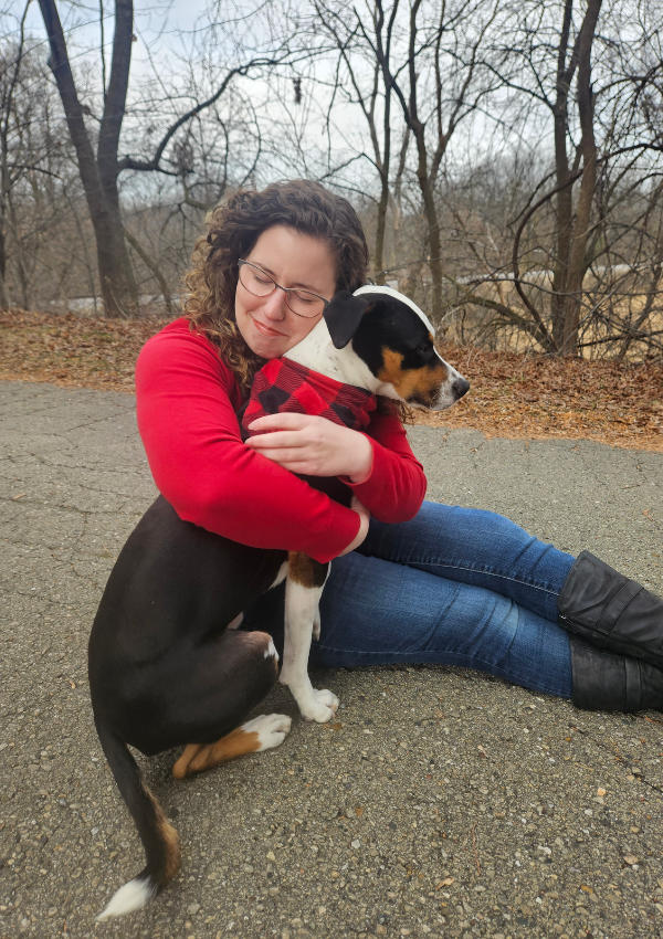 Picture of Jacqueline LeFevre hugging her dog, Sam, a tri-colored mixed breed