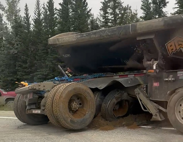 This image shows the end of a large ore haul truck partially suspended after running into a ditch.