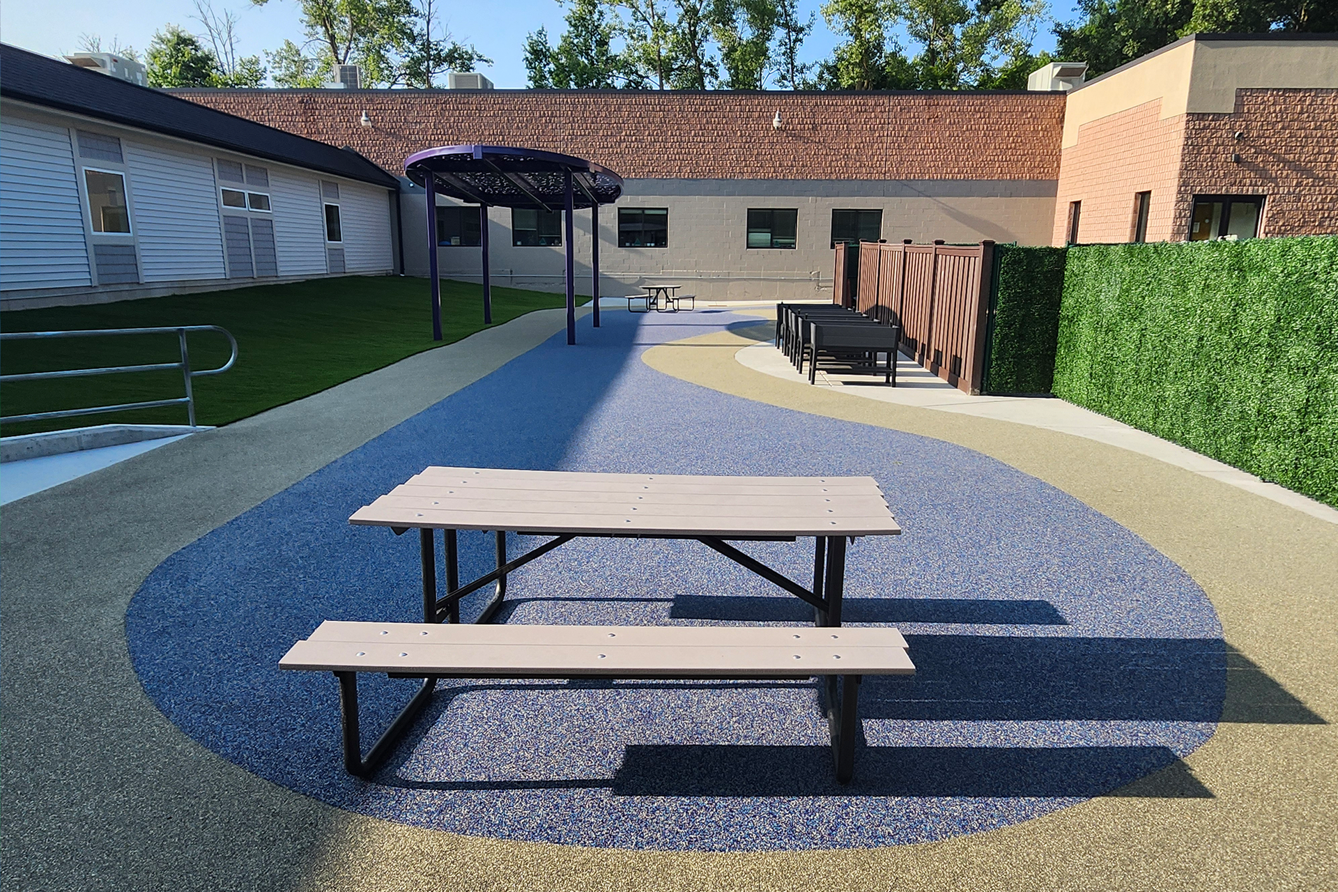 A picnic table outside on a new rubber surface.