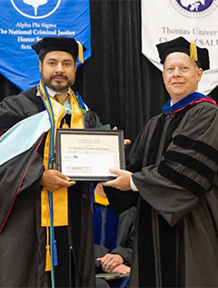Dr. Remigio Padilla-Hernandez receives the Vulcan Excellence in Teaching Award from Dr. John Meis, Provost.