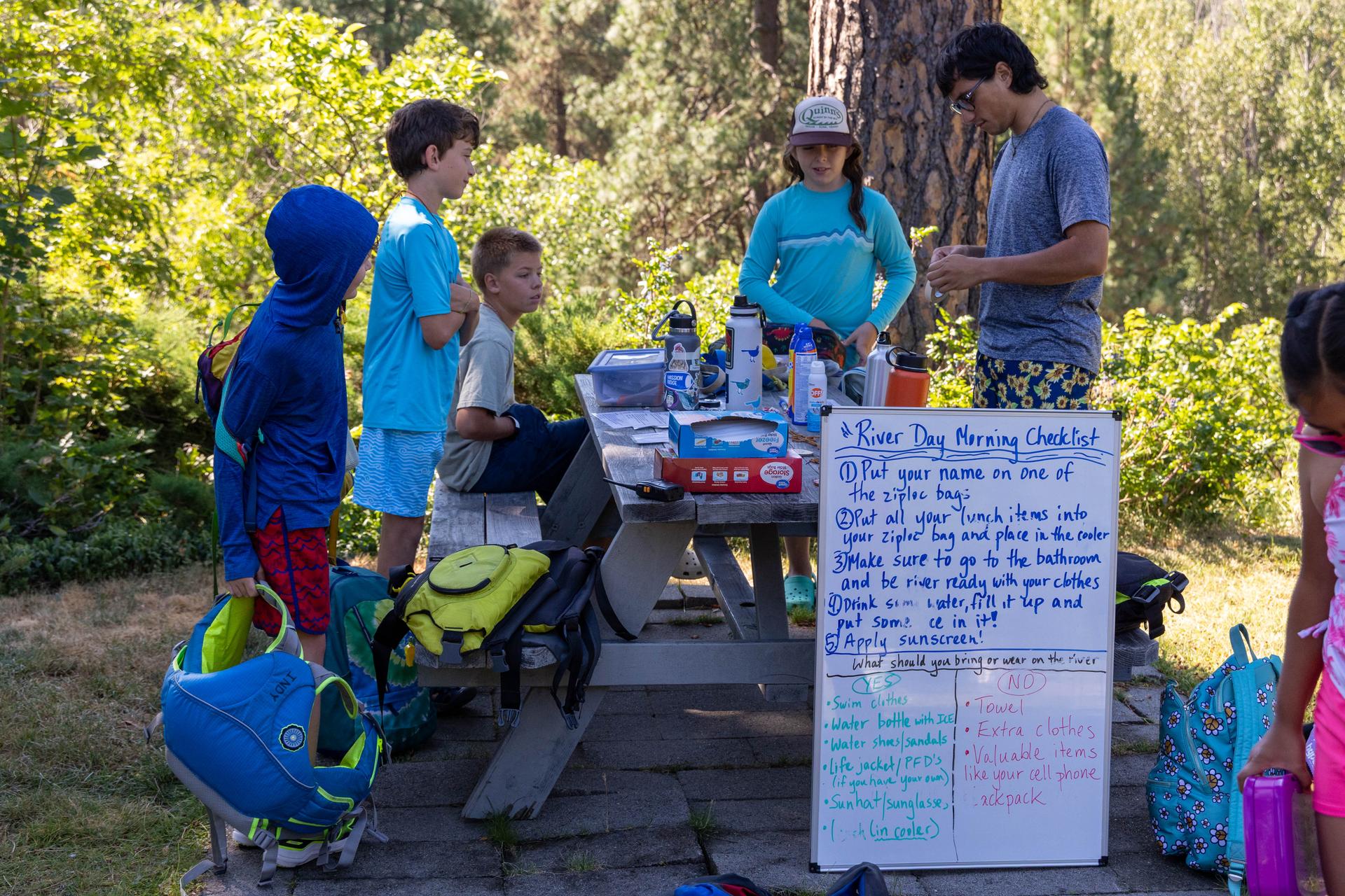 2025 WRI Summer Camp preparing for the day with Educators and campers around a picnic table.