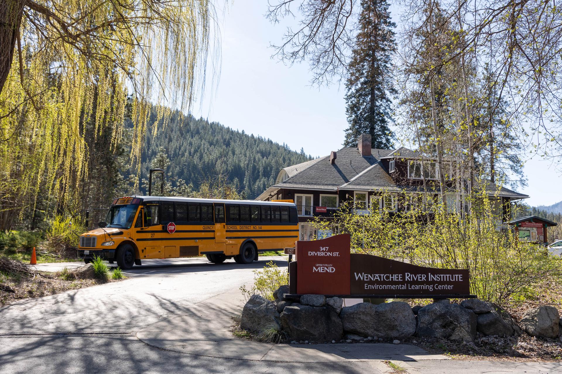 School bus parked outside of the entrance at Wenatchee River Institute for a Field Day.