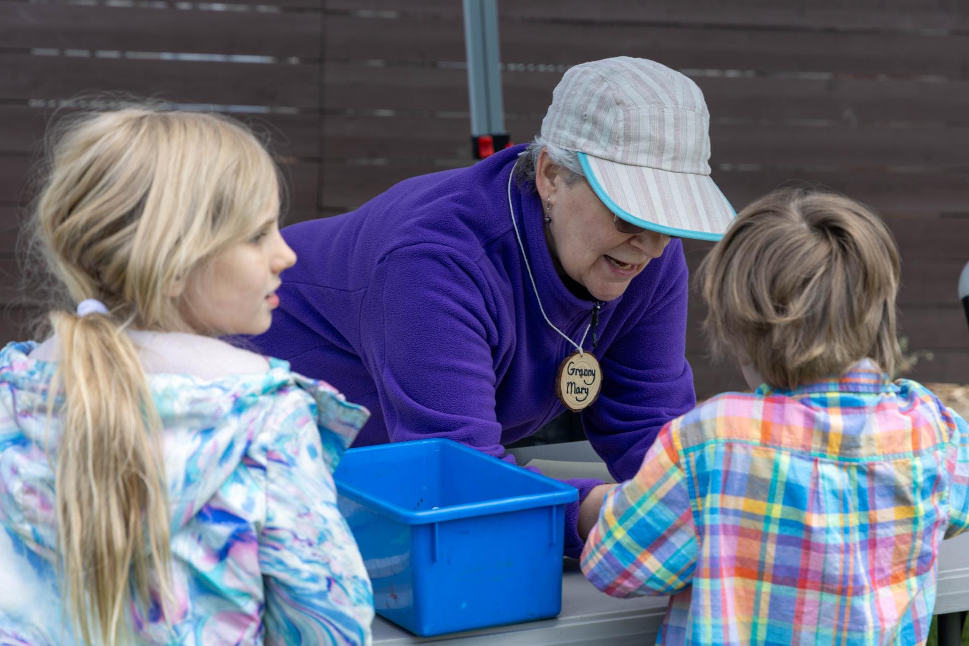 Volunteer assisting kids in an educational activity at a WRI Booth at Bird Fest Community Fair 2026.