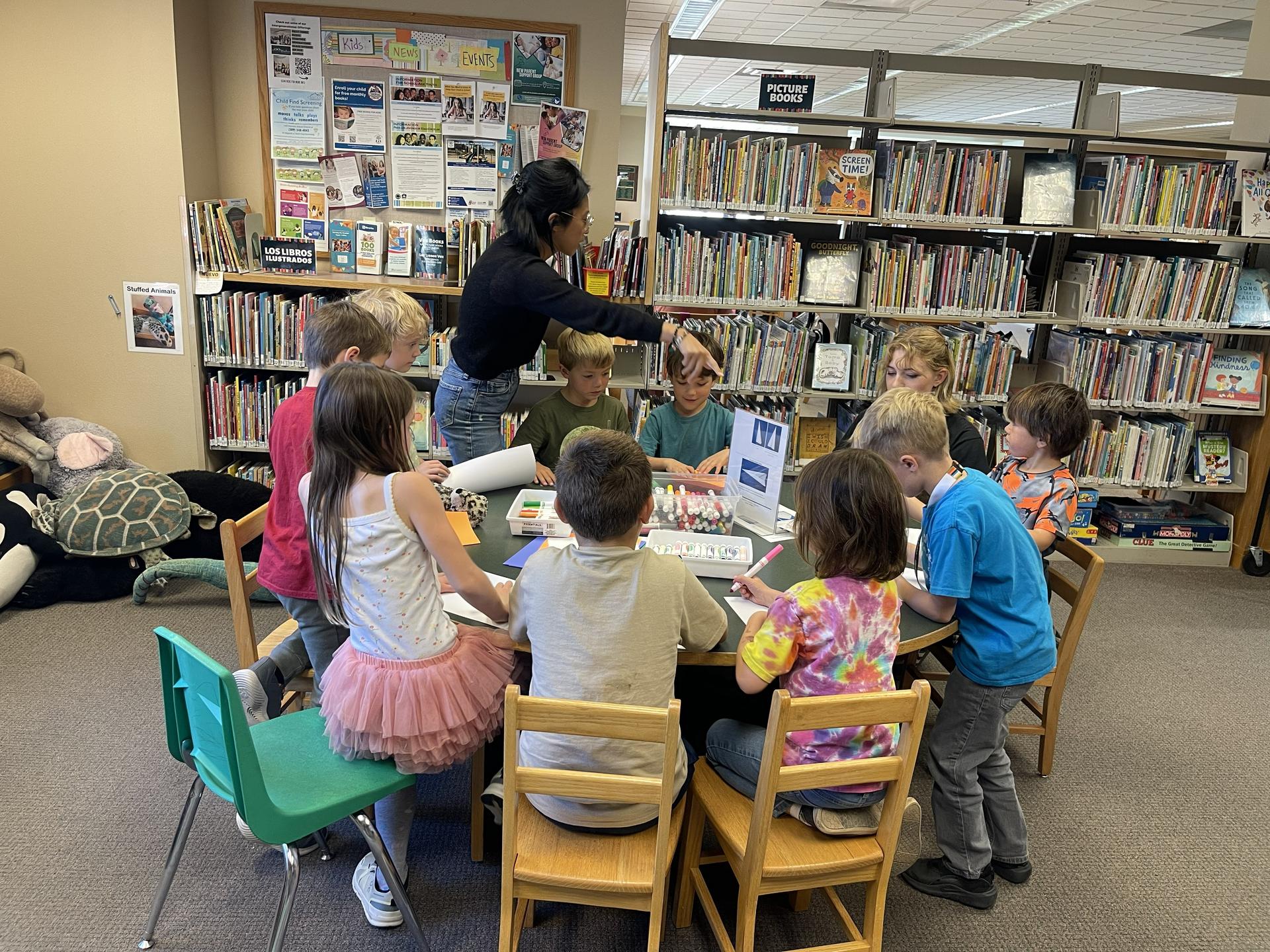 Leavenworth Public Librarian, Hannah, works with WRI After School Program kids on an activity in the library.