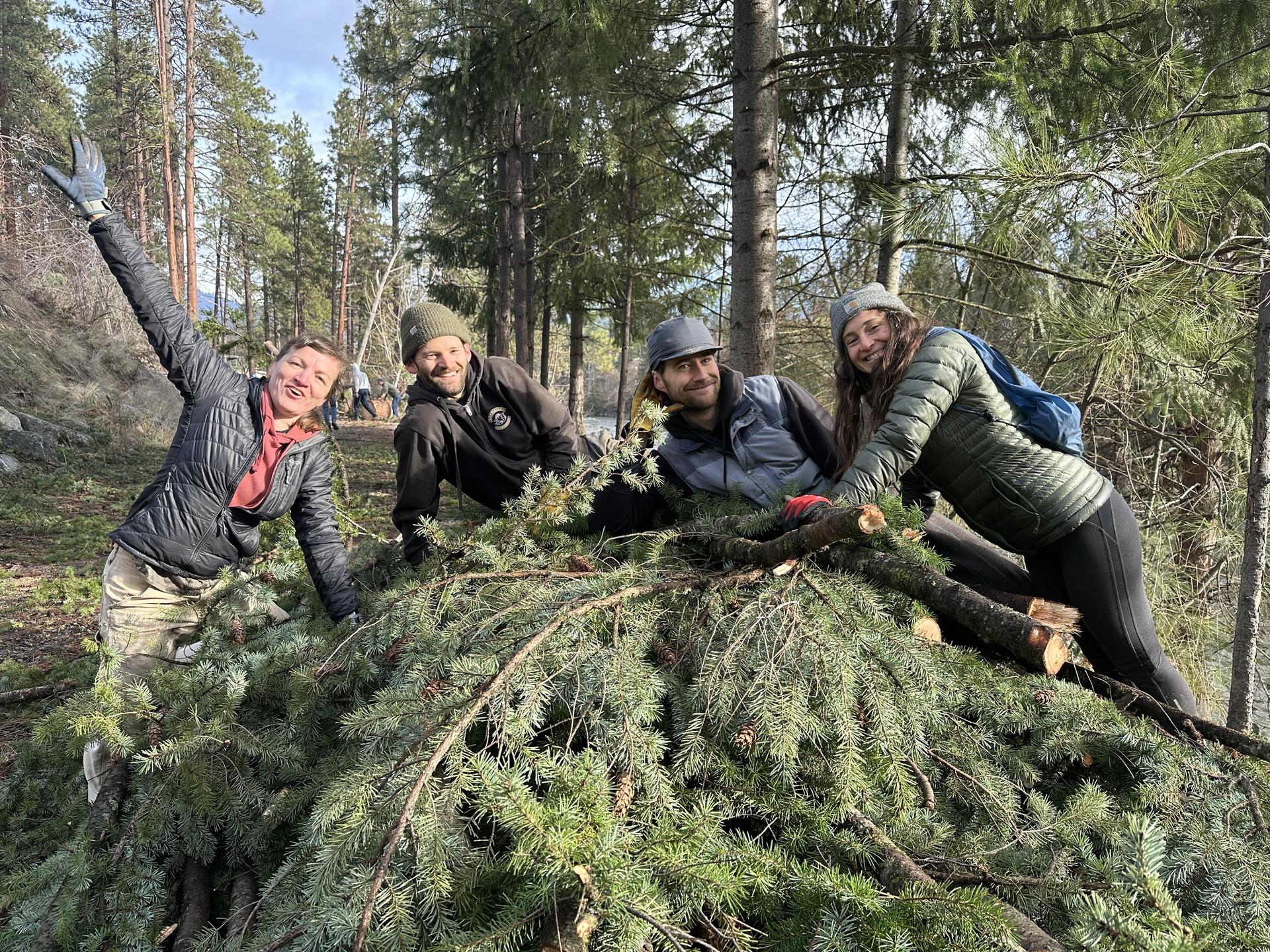 Volunteers posing on a pile of debris they cleaned up at WRI.