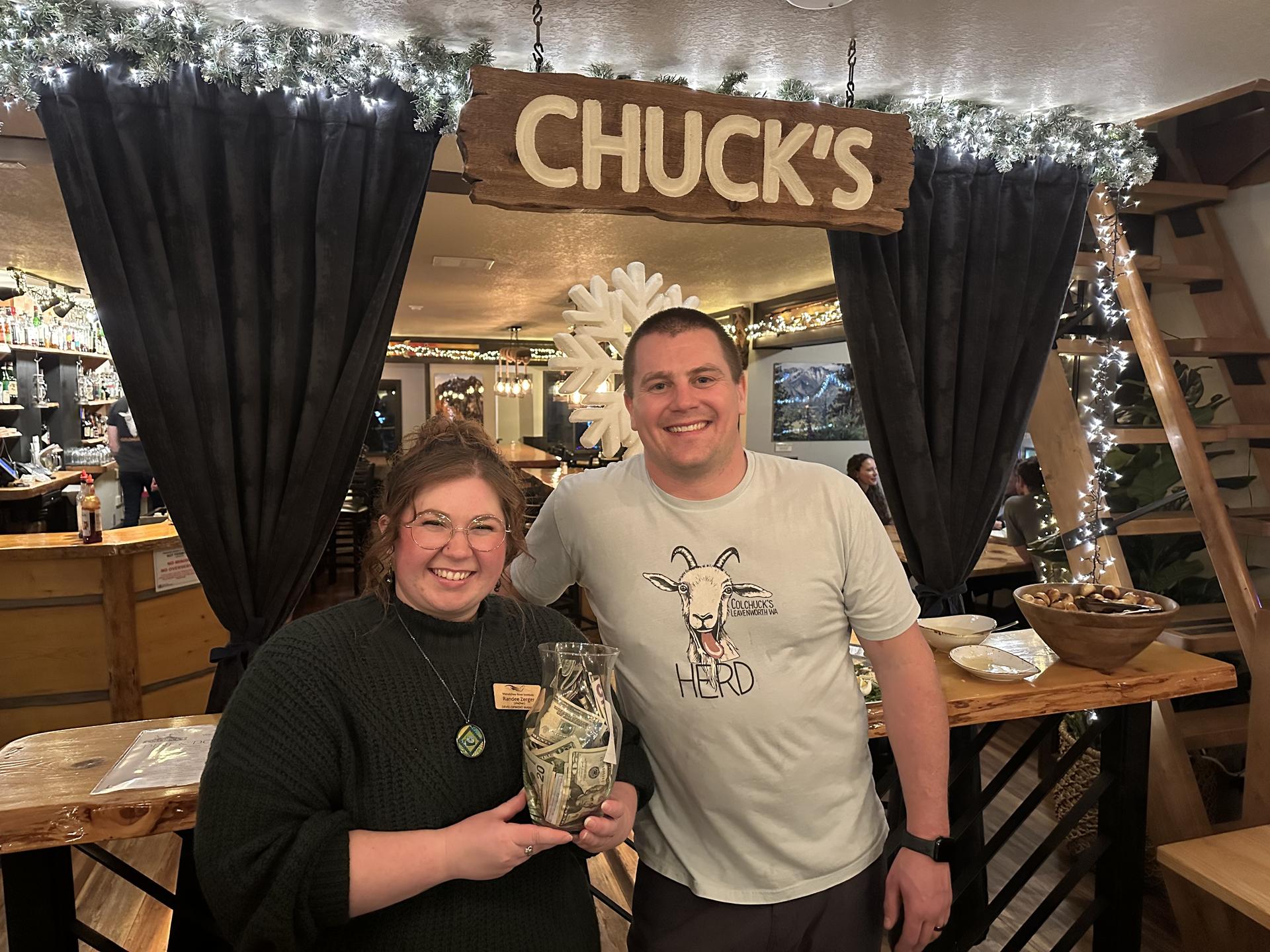 Randee Zerger, WRI's Development Manager, with Kyle Martin, Colchuck's General Manager, posing with the vase of cash raised at the Community Benefit Dinner.