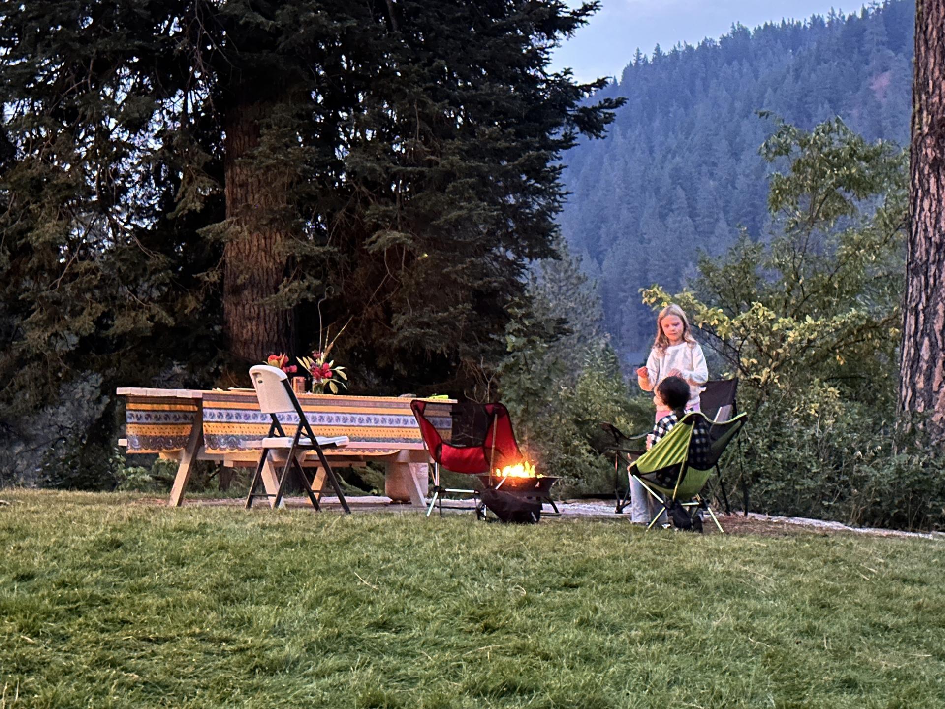 Two kids sitting by a fire on the WRI campus.