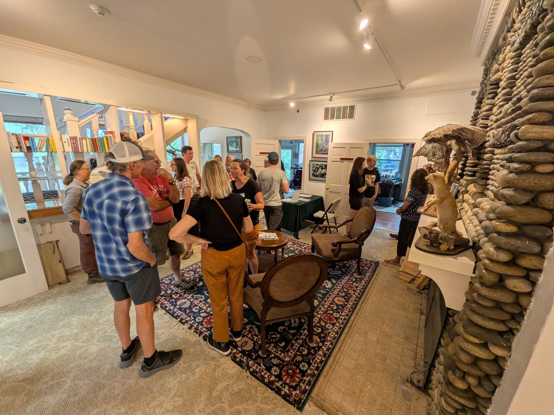 WRI hosting a Volunteer Open House in September of 2025. Participants mingle near the fireplace in the River Haus.