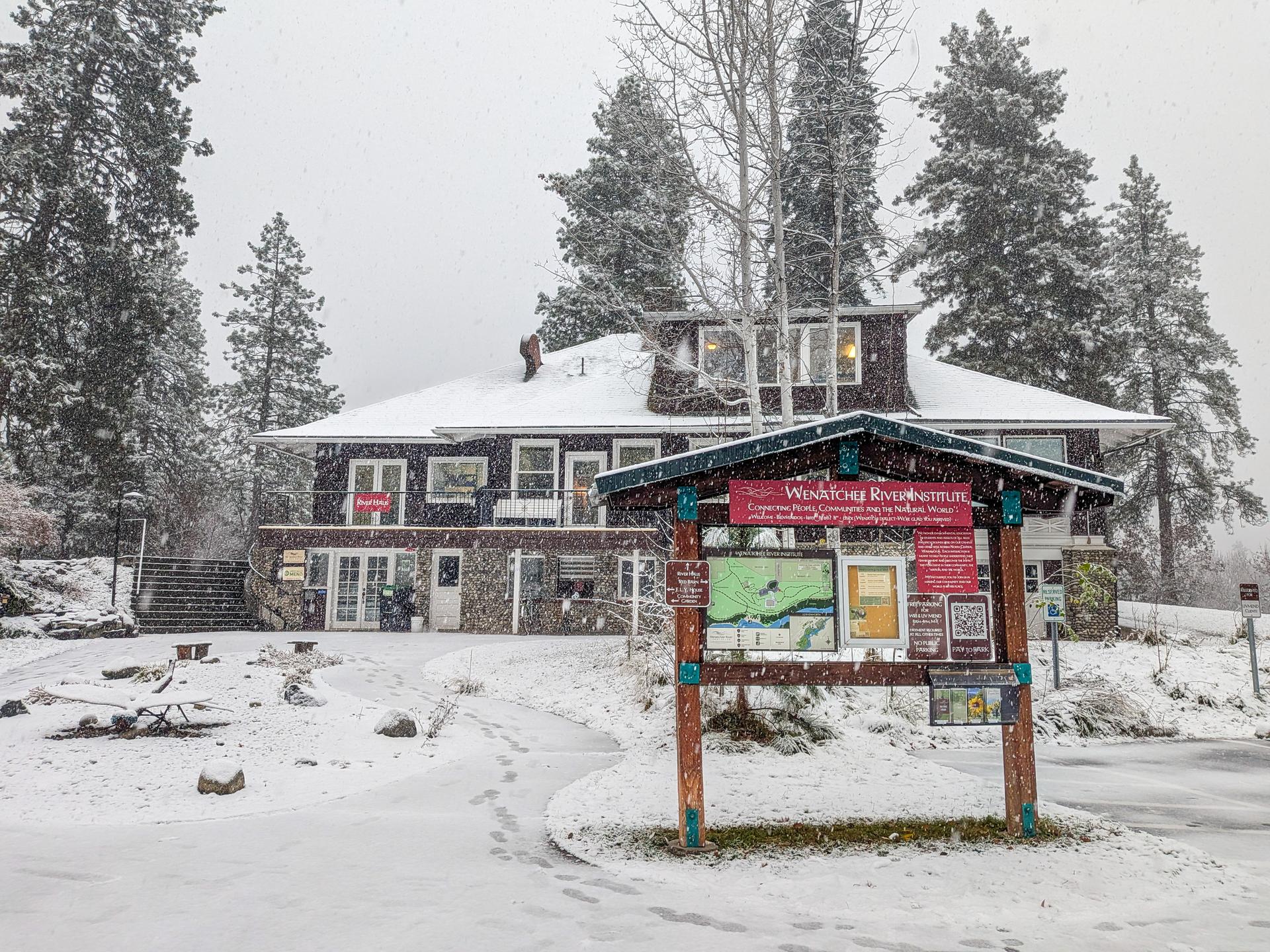 Image of WRI River Haus and entrance sign with snow falling.