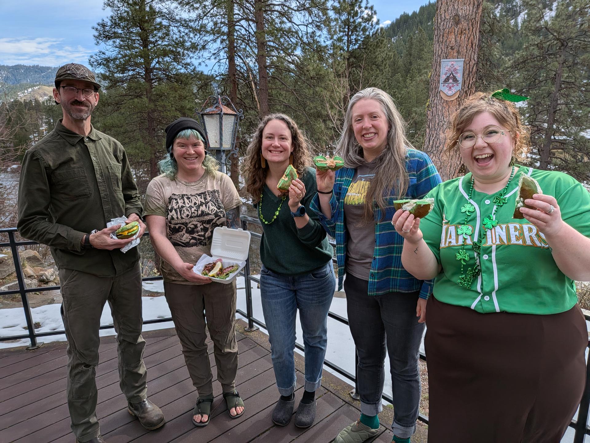 WRI Staff holding green bagels for St. Patrick's Day.