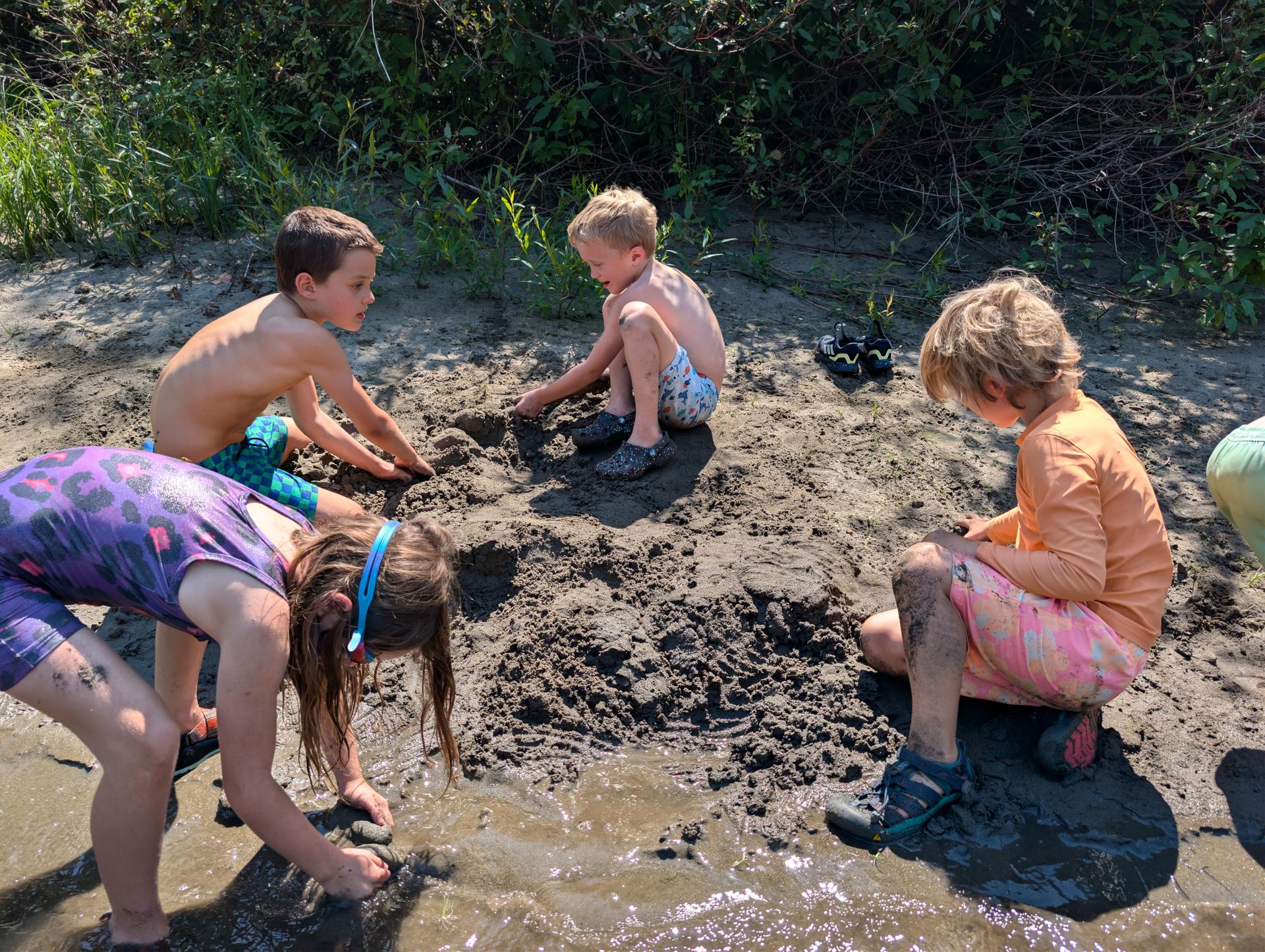 WRI Amazing Artist Summer Camp kids building with sand on the banks of the river.