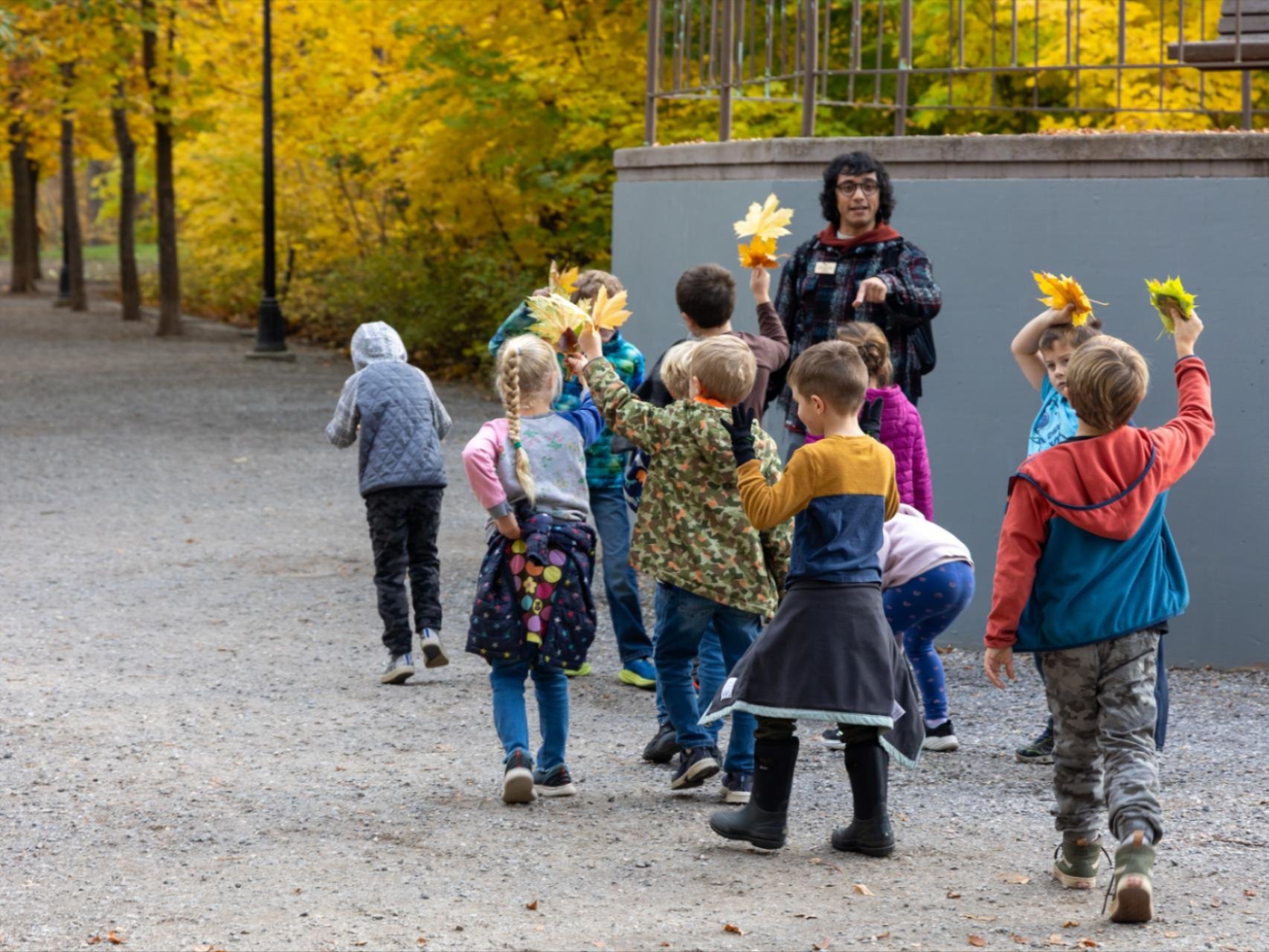 WRI Educator, Fern, walking Fall Break kids around the Leavenworth Waterfront holding colorful leaves.