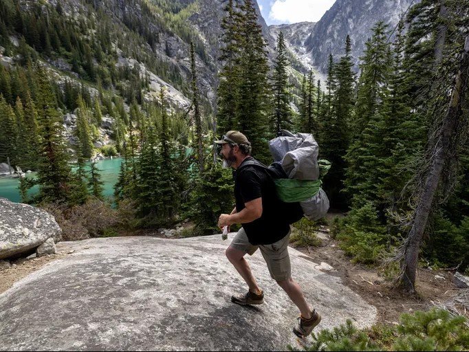 Mat Lyons, executive director of TREAD, a nonprofit advocating sustainable outdoor recreation, tears down an abandoned campsite at Colchuck Lake on Thursday. (Nick Wagner / The Seattle Times)