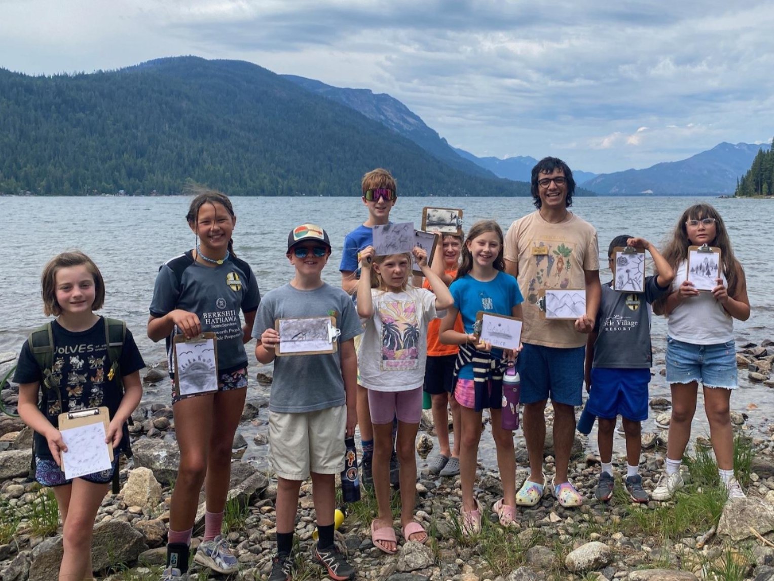 Adventurous Artists spending time by Lake Wenatchee showing off their charcoal paintings