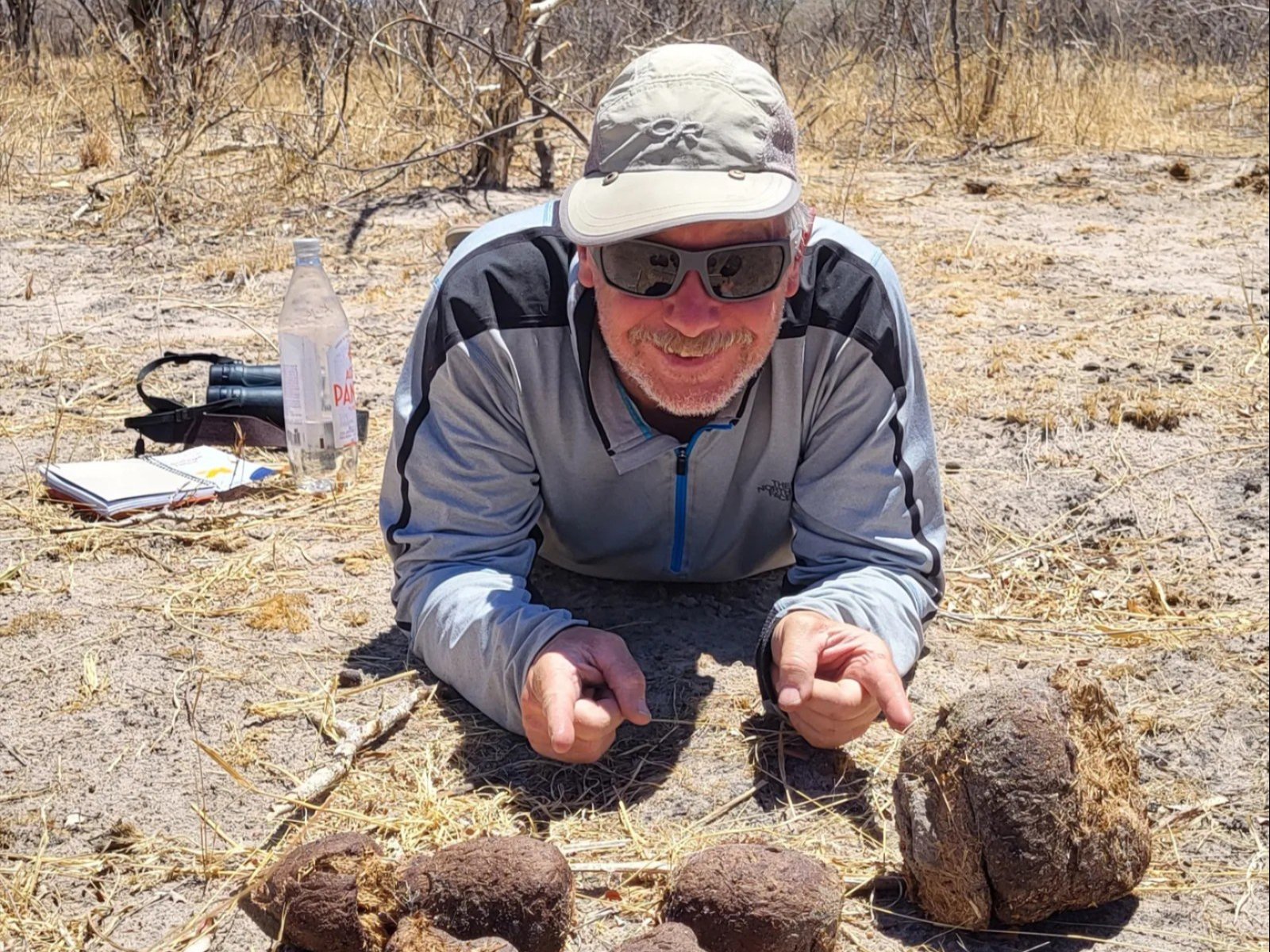 An image of  Kirk Beckendorf pointing at scat.