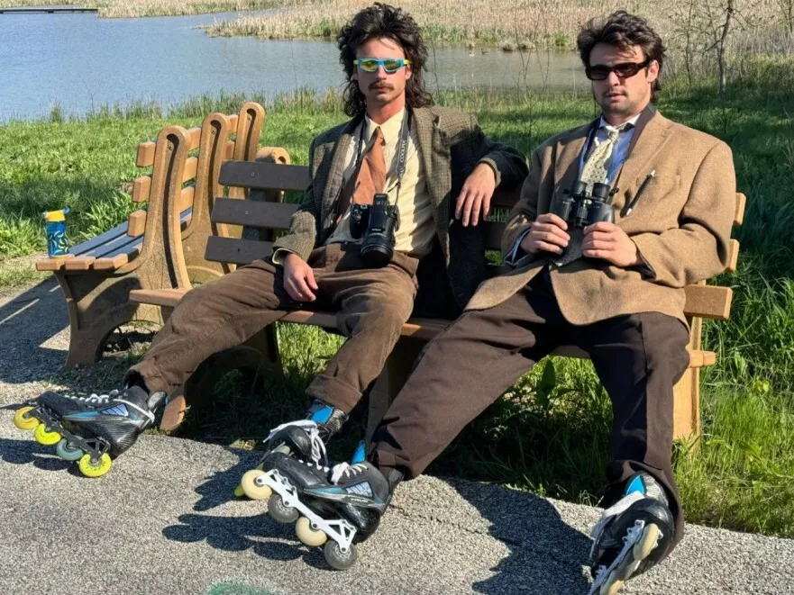 Photo from the film Listers of men in rollerblades, suits, and binoculars.