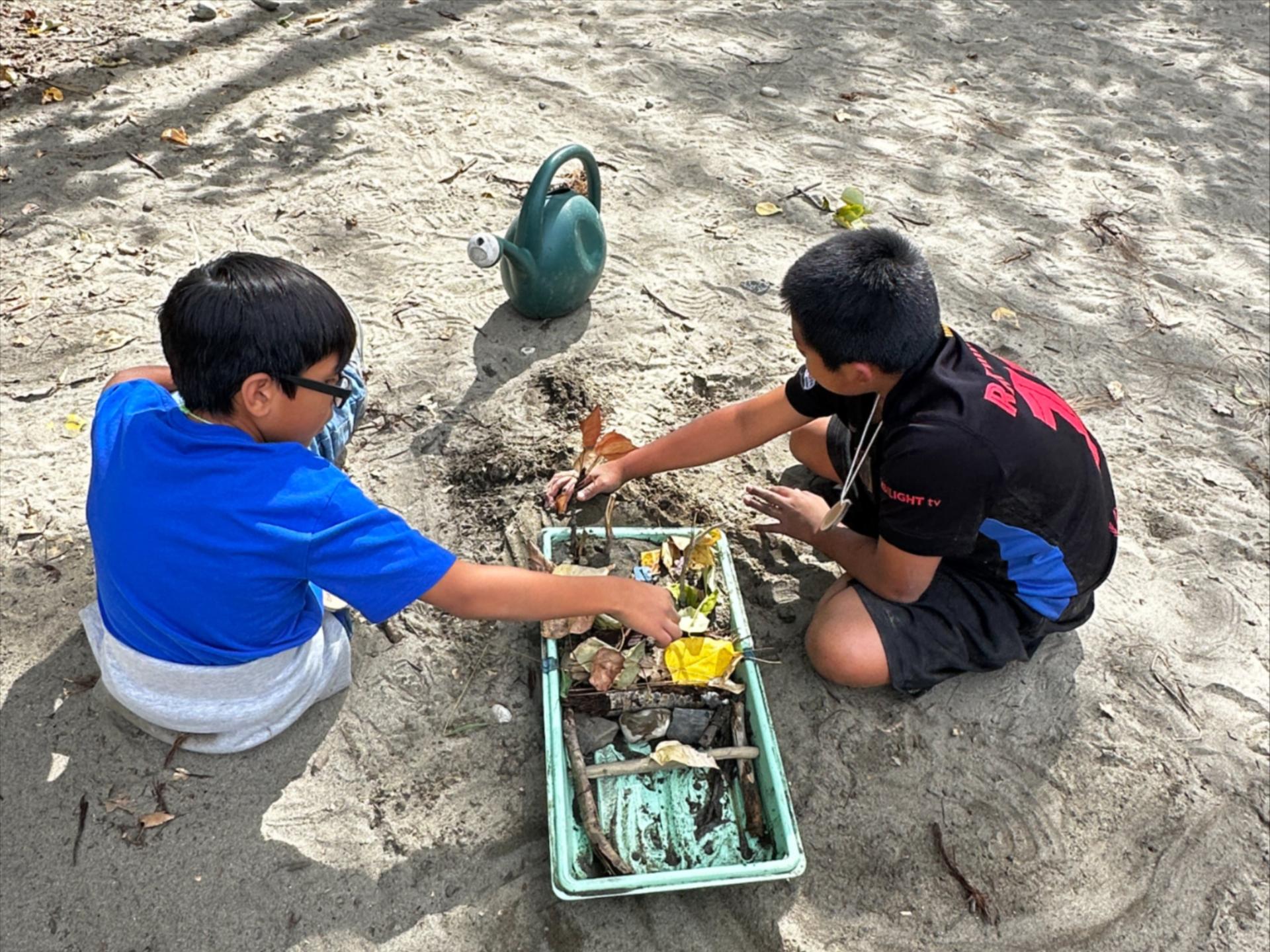 2 young boys doing an Earth Explorer activity with Wenatchee River Institute at a Field Day