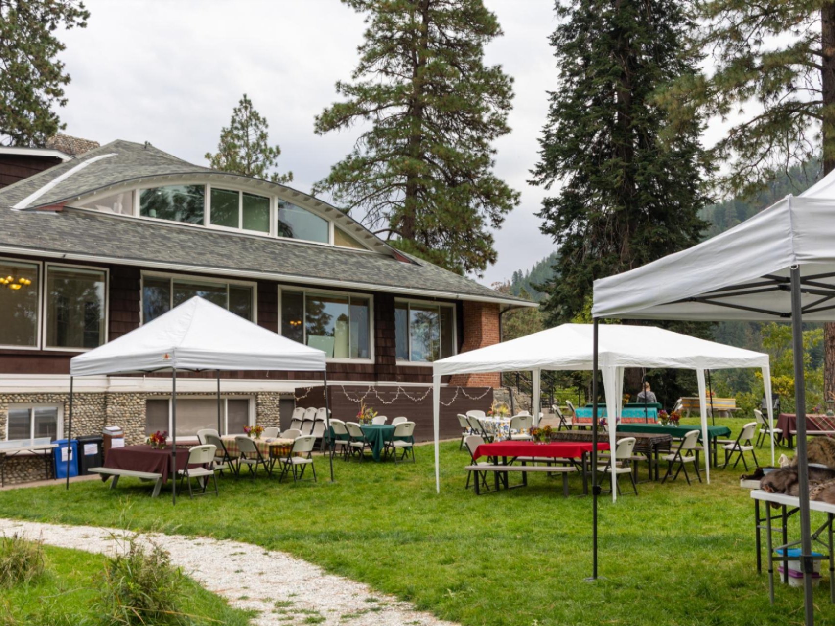 Image of the River Haus Lawn set up with tables and canopies for the 2025 Sunset & S'mores event.
