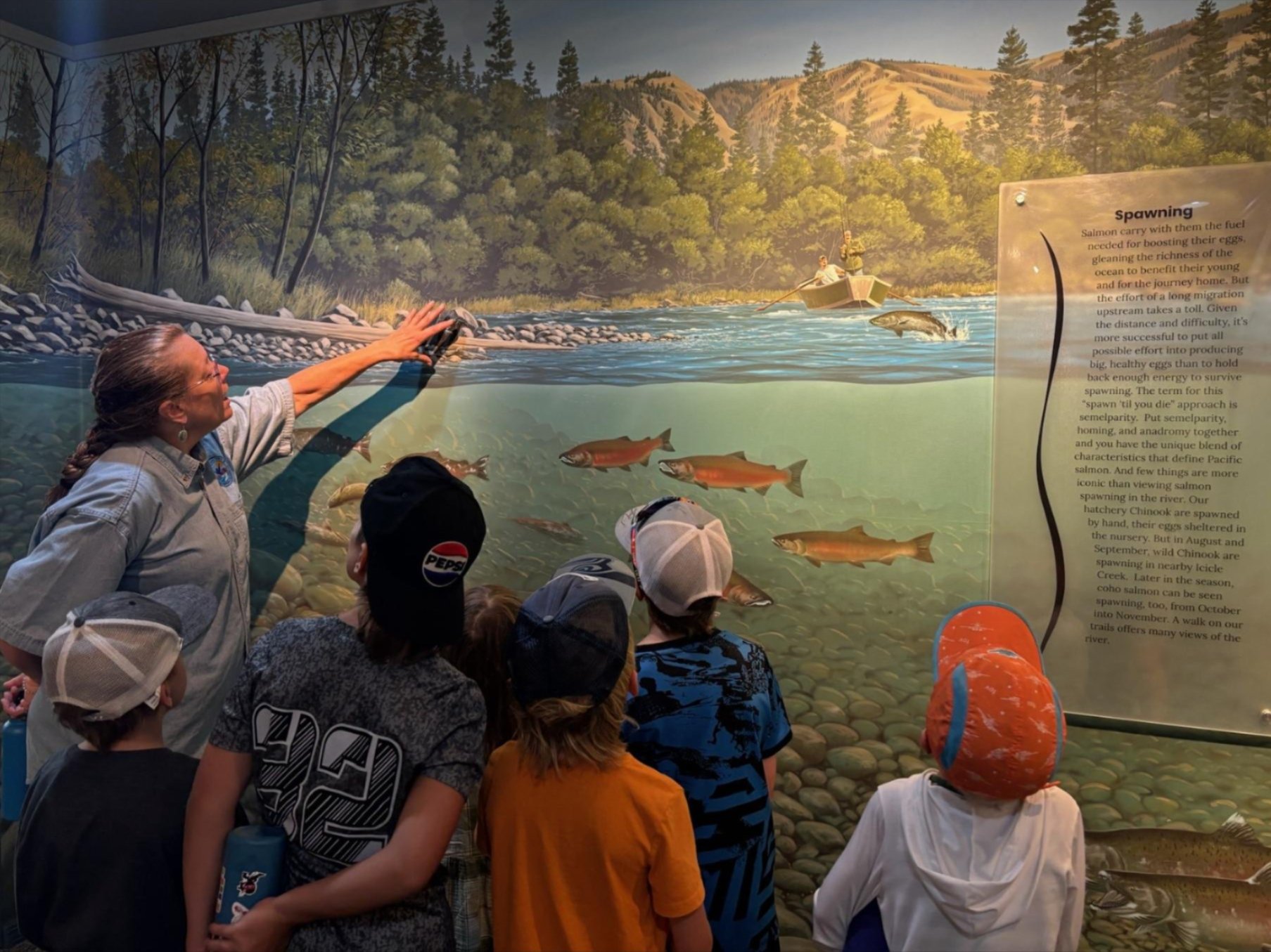 Campers gather around instructor inside the hatchery's Visitor Center to learn about salmon and other wildlife
